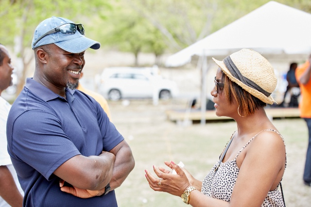 Chief Executive Officer of the Nevis Tourism Authority Greg Phillip speaking with a patron at The Nevisian Mango Feast on Oualie Beach on July 12, 2015. Photo by Refined Digital Media